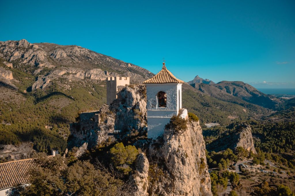 Campanario de Guadalest sobre la peña con el valle al fondo